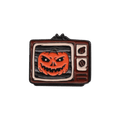 A retro TV-shaped enamel pin featuring an orange jack-o'-lantern on a white background