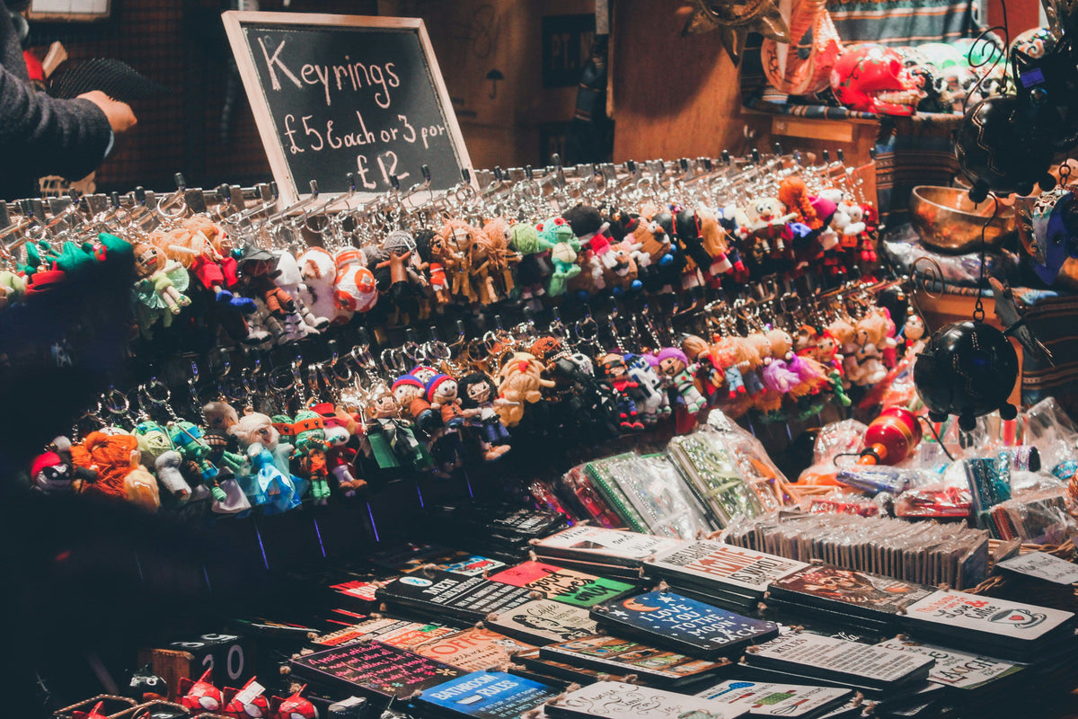 Table with various small items including keychains and trinkets at a market stall