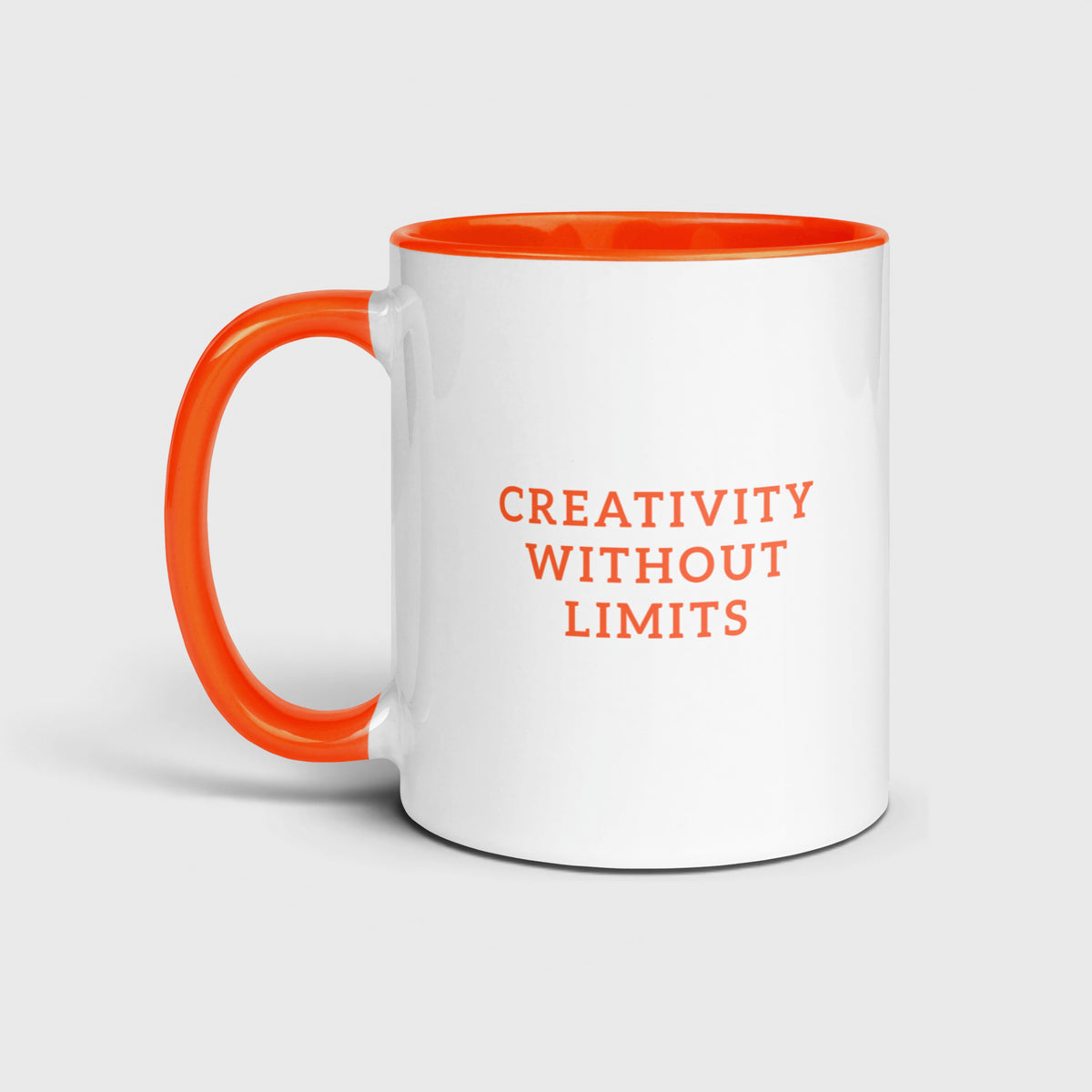 White and orange Oketo Design coffee mug featuring orange lettering that states "CREATIVITY WITHOUT LIMITS"