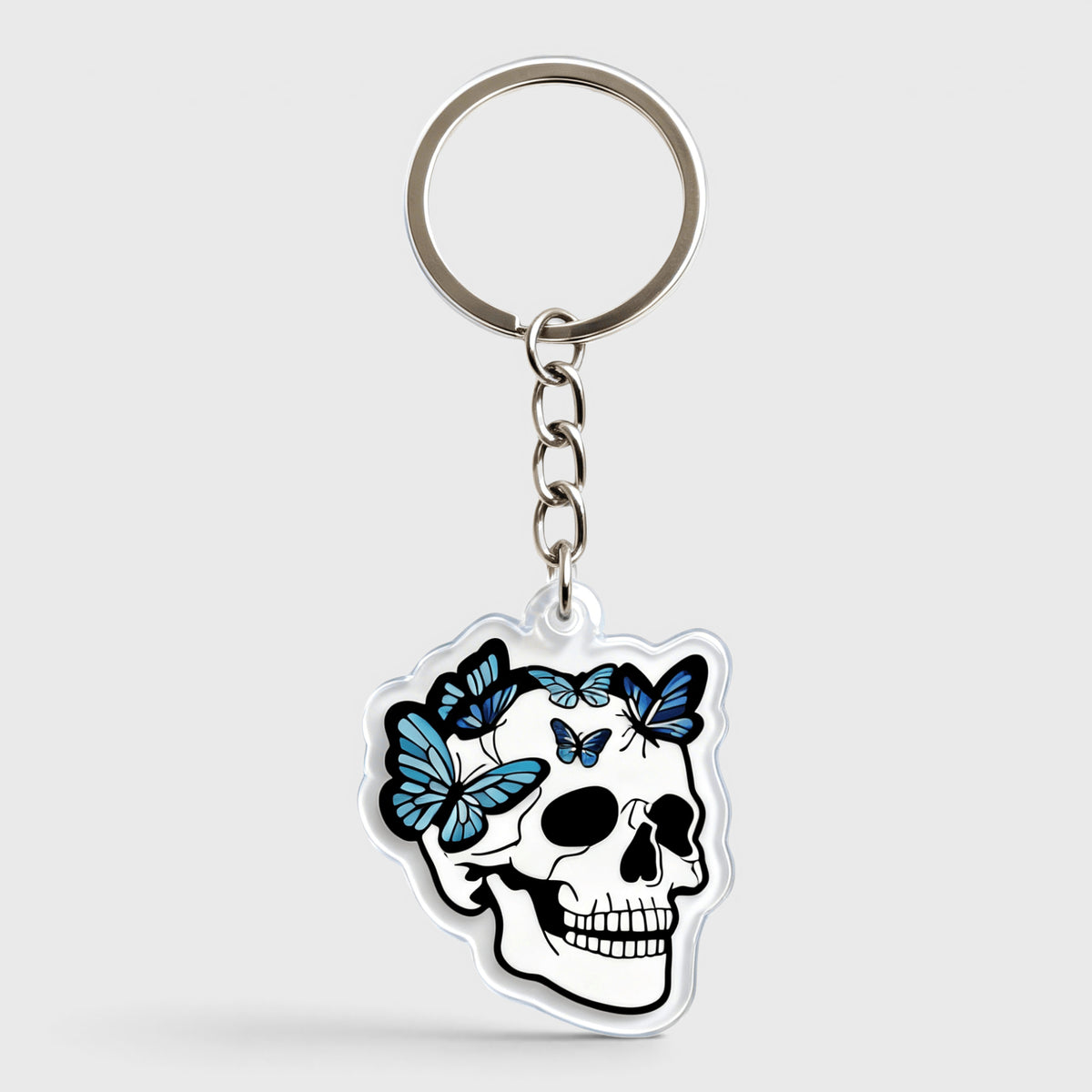 White skull keychain decorated with blue butterflies and floral details