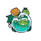 A nature-themed enamel pin with frogs swimming inside a potion bottle on a white background
